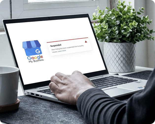 Google Business Profile suspended notification on laptop screen showing quality issues warning